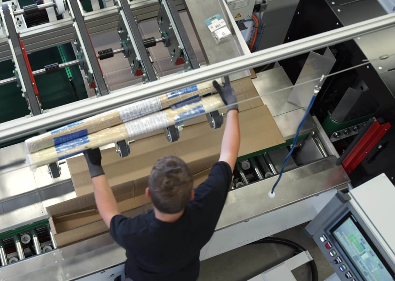 Facido - Employee packs products at Packsize folding table. 