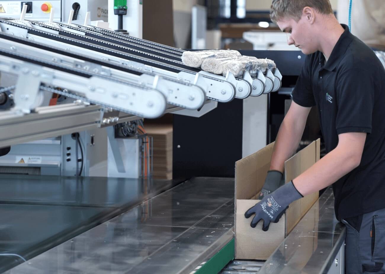 An image of a warehouse worker packing a long-goods item using Packsize technology at Facido.