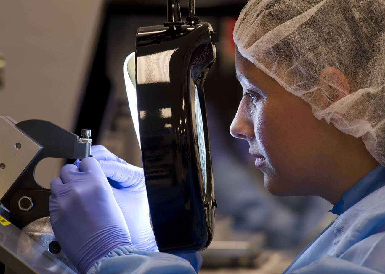A photo of a scientist working with a magnifying device at Boston Scientific.